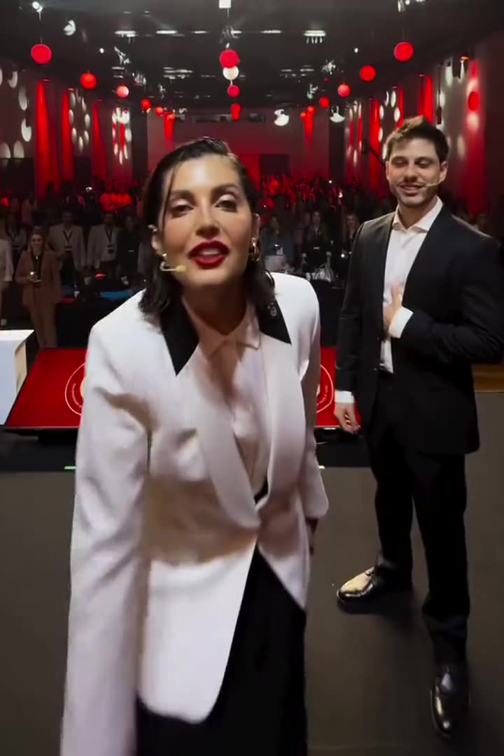 Plateia com os celulares acesos, atrás de Ana Luiza e Leonardo Rosso no palco